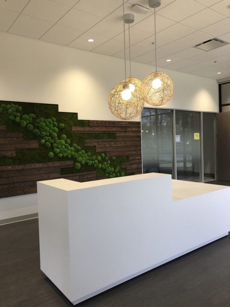 front desk entrance at an office building, with greenery on the wall