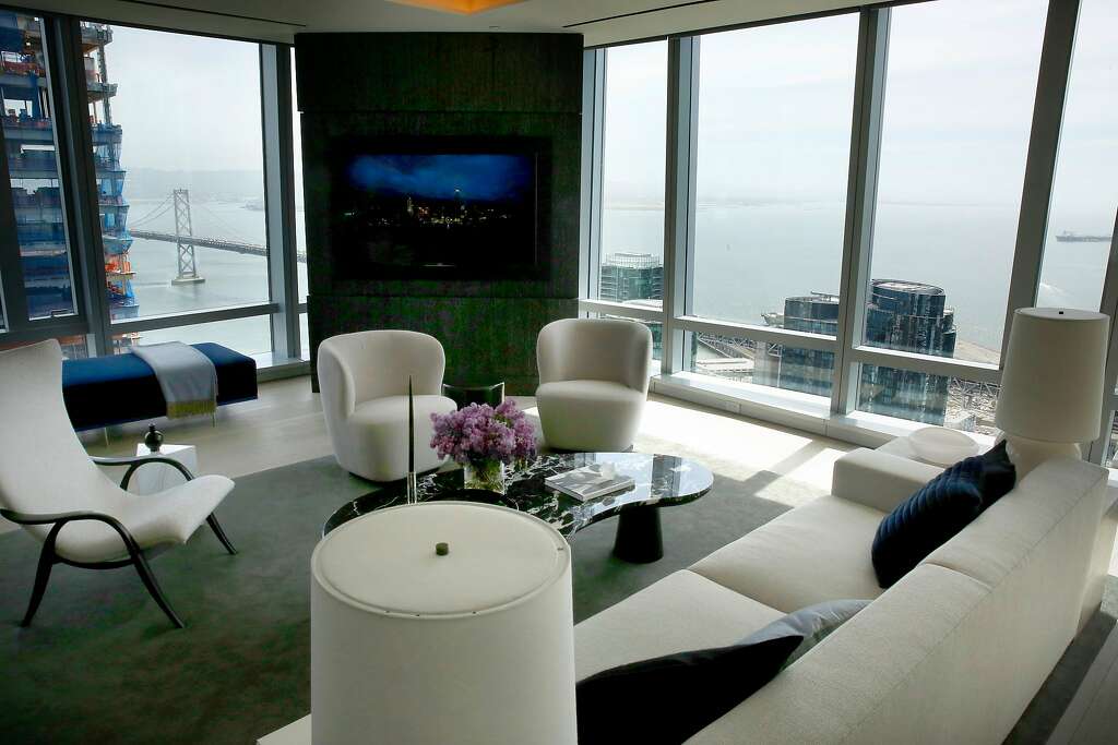 The Sky Lounge, top, looks out over the Bay Bridge from the 39th floor of 181 Fremont St. Above, the living room in the model residence at the skyscraper. Photo: Michael Macor / The Chronicle