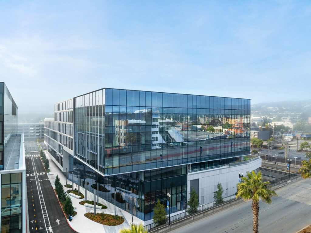 Modern glass lab building overlooking city streets and train tracks