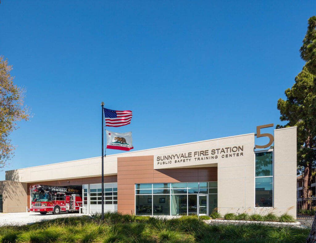 front facade of a new fire station, with firetruck parked outside.